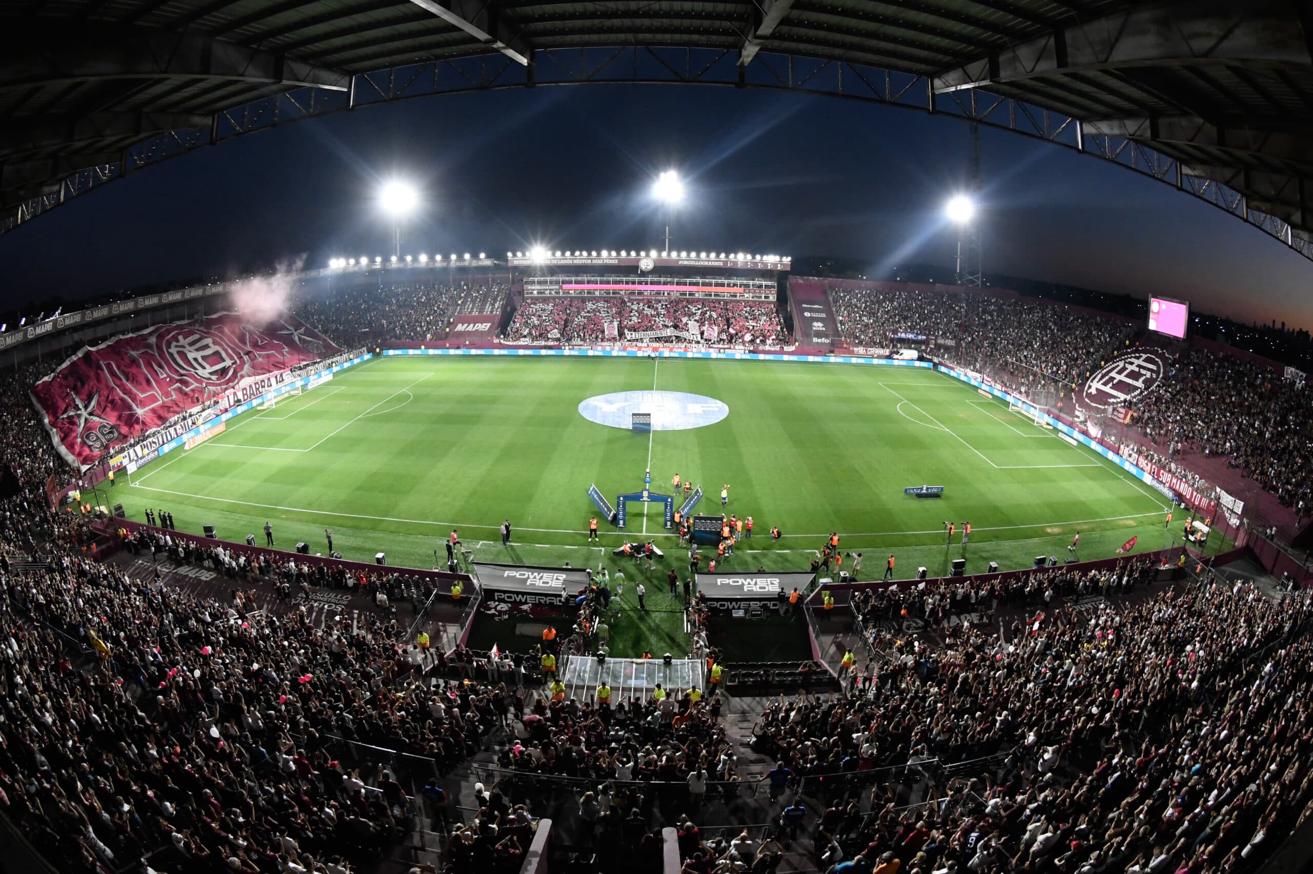 La Fortaleza, estadio del Club Atlético Lanús, iluminado de noche con hinchada en las tribunas